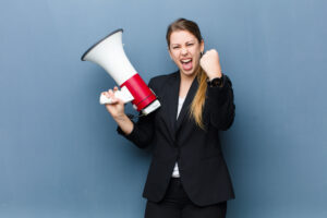 How do you communicate a clear content strategy and message map to all marketing channels? Happy businesswoman holding megaphone