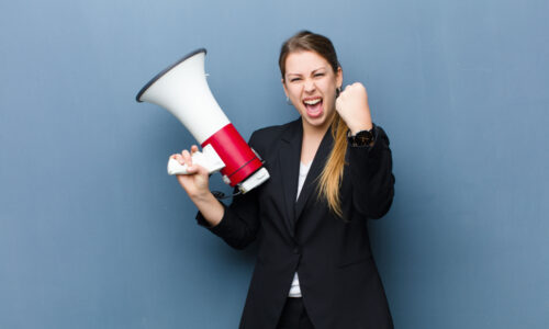 How do you communicate a clear content strategy and message map to all marketing channels? Happy businesswoman holding megaphone